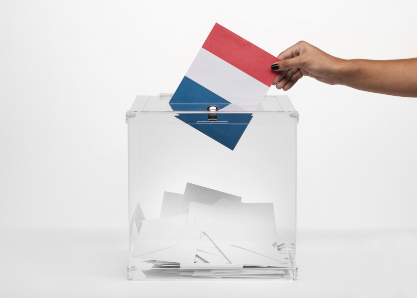 person-putting-france-flag-card-into-ballot-box